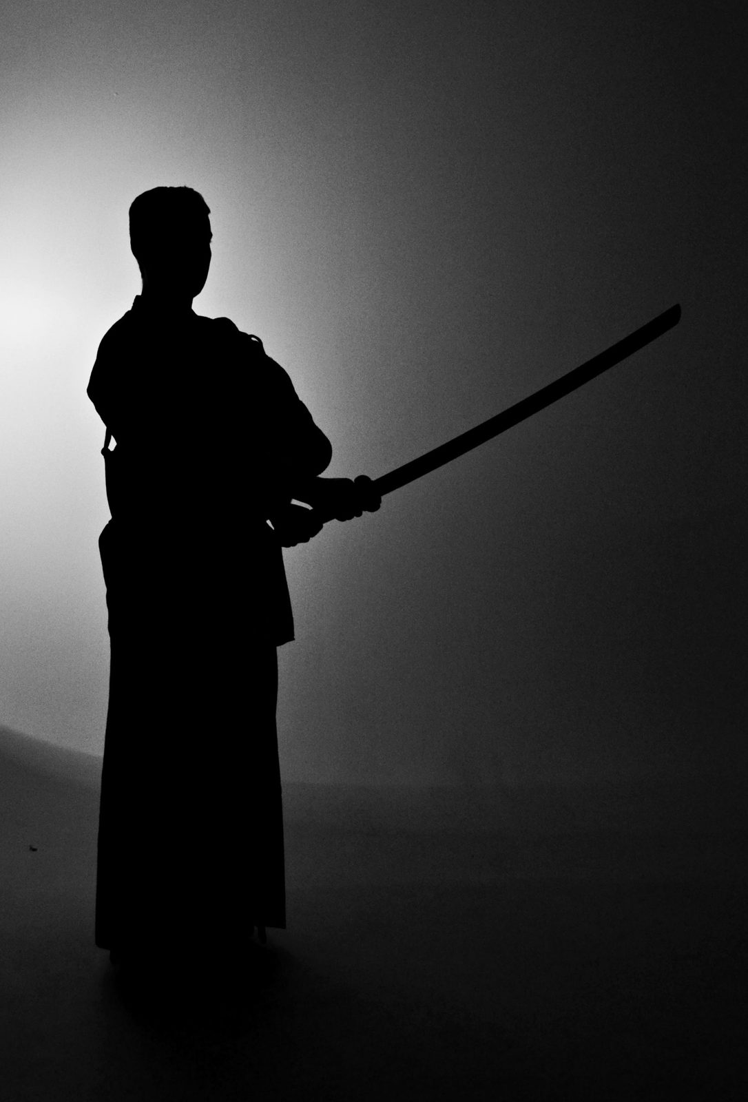 Silhouette of a kendoka standing with a wooden sword