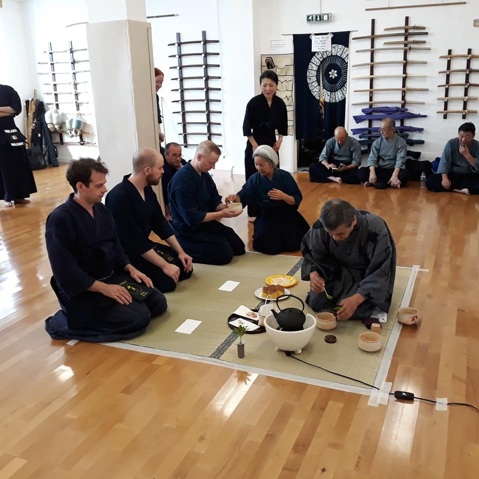 Kendoka kneeling on a tatami mat during a Japanese tea ceremony at a seminar