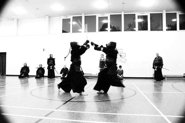 A practice bout in the sports hall, with club members watching