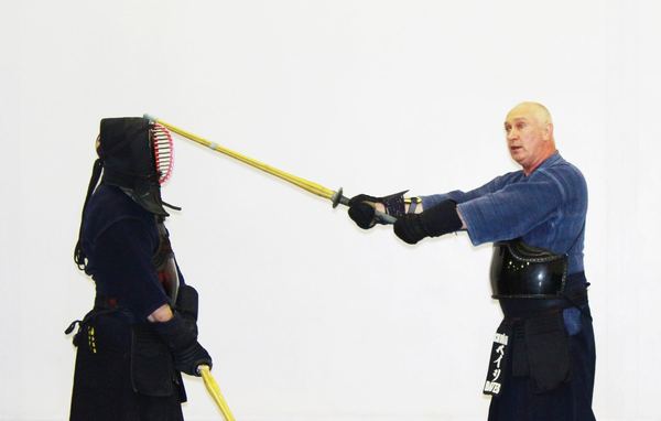 An instructor practising with a student in armour